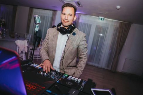 a man wearing headphones and standing in front of a microphone